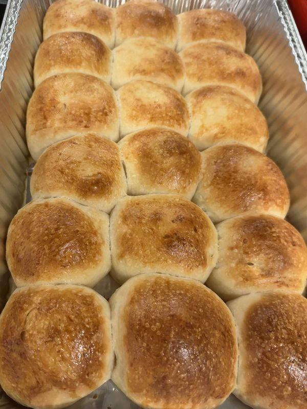 A pan of golden-brown sourdough dinner rolls